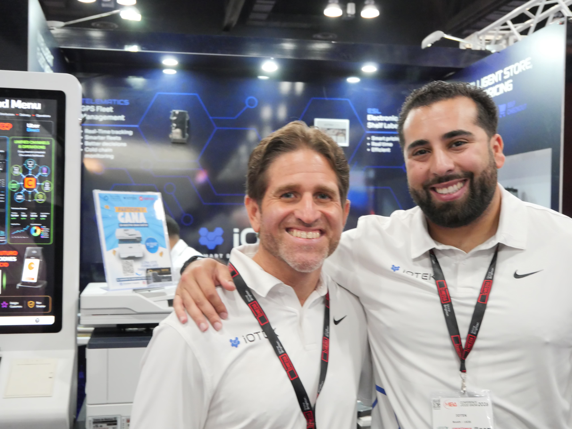 iOTEK team members at the MIDA 2026 booth in front of the Telematics GPS Fleet Management display